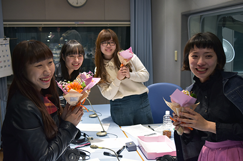 スタッフから花束を受け取ったＴＨＥ　ＴＯＭＢＯＹＳのメンバーは笑顔。（写真左から、のん、タバタヒナ、ＧＧワカナ、和木マドカ）　（写真：ラジオ関西）