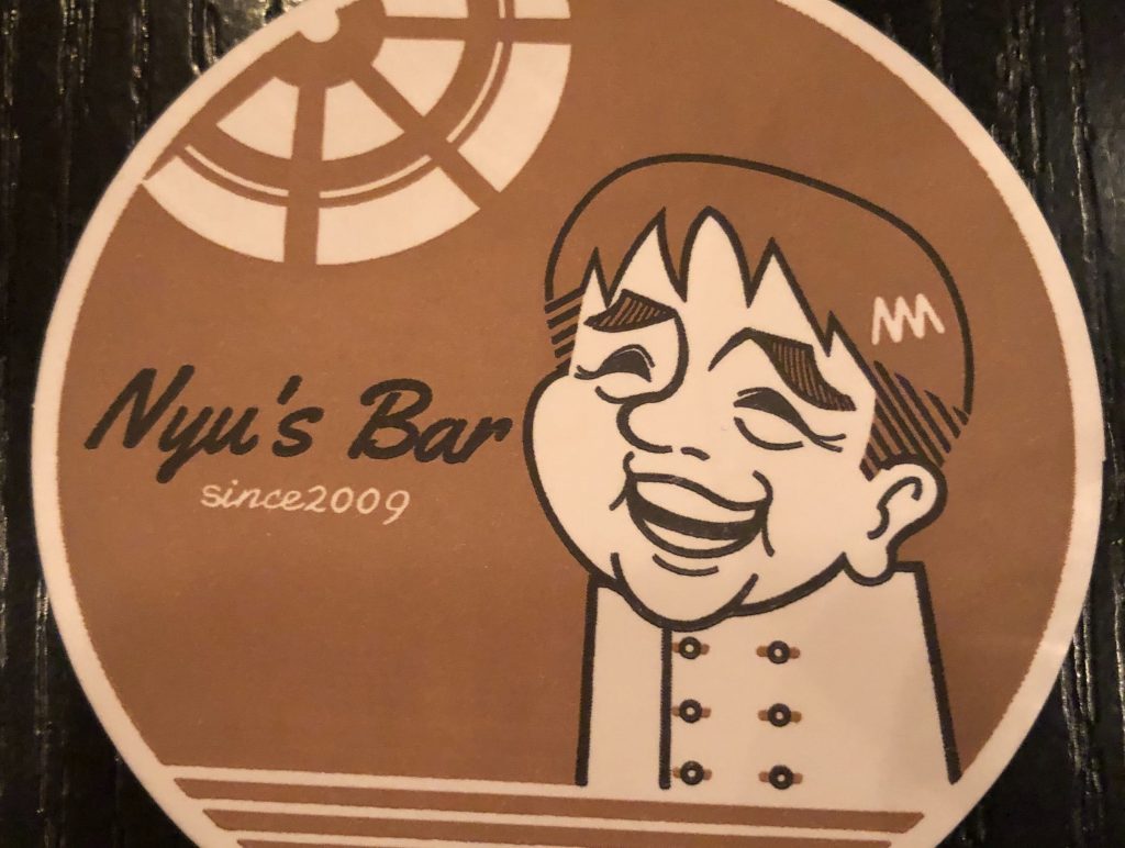 入田シェフがデザインされた特製コースター。“ニュウタのバー”で“Nyu's Bar”だそう