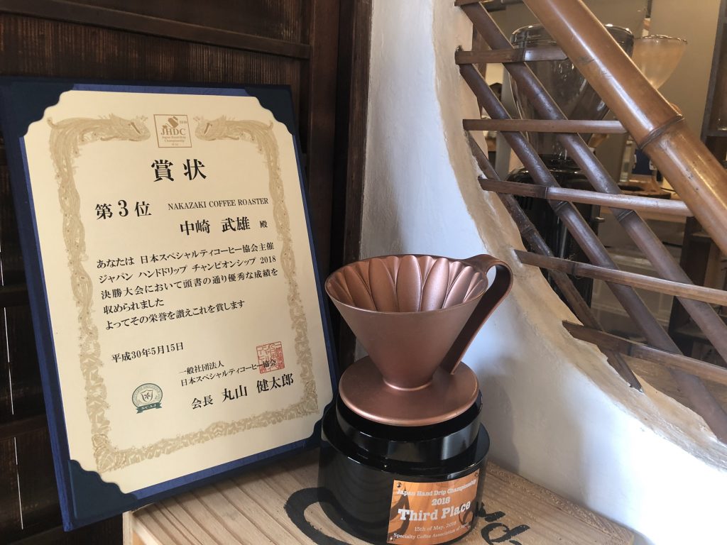 「ジャパン ハンドドリップ コンテスト（JHDC）」3位の賞状とコーヒードリッパーを模したトロフィー