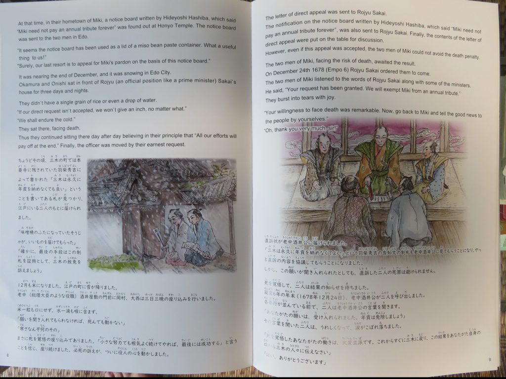 三木市国際交流協会が制作・発行した絵本「三木義民の物語『身を捨ててこそ』」。左ページの絵は老中の屋敷前で座り込む義民、右ページは老中の言葉を聞く義民が描かれている。