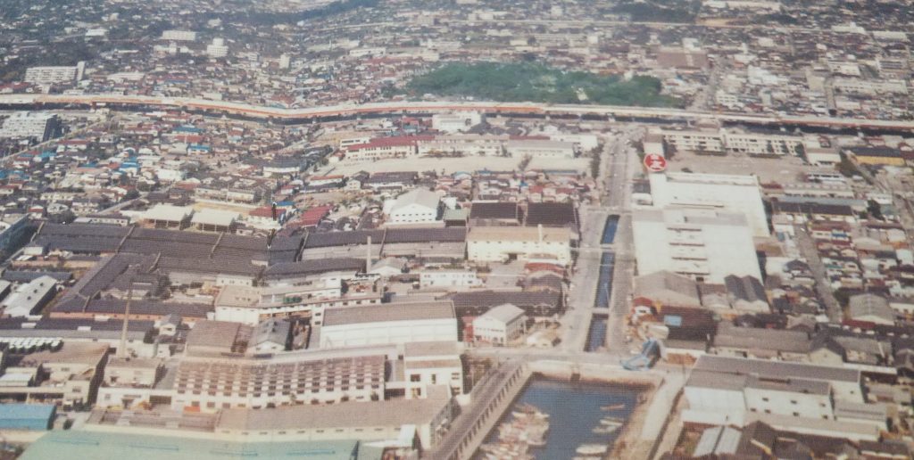 昭和40年代の戎蔵（中央右寄り）周辺の航空写真。真南に西宮ヨットハーバー、北側に西宮神社の杜、真西一帯に蔵が拡がる（画像提供・辰馬本家酒造）