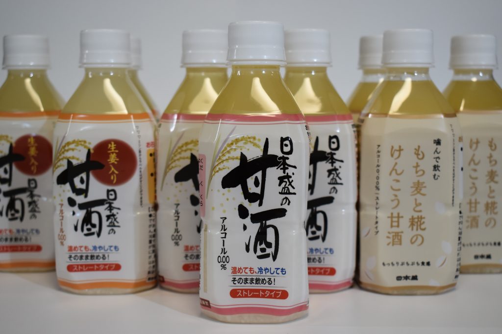 日本盛の『甘酒』（左）と『噛んで飲む もち麦と糀のけんこう甘酒』（右）