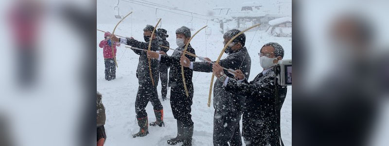 雪山に向けて破魔矢を射る神事の様子