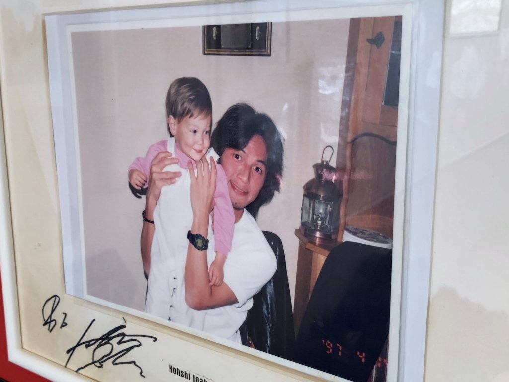 店主・ハンセンさんの息子を抱きかかえる稲葉浩志さん。写真の日付は1997年4月14日となっていて、直筆のサインが添えられている。