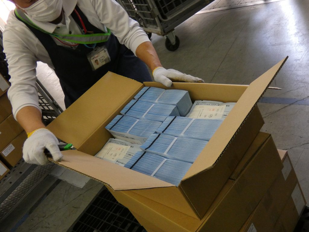 接種券が入った段ボール箱が約600箱到着、局員らが発送作業した＜19日午前 神戸中央郵便局＞