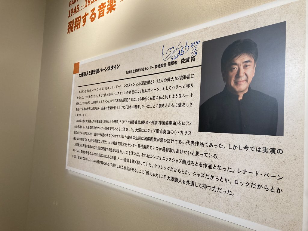 「大澤壽人はわが師・バーンスタインと共通点も多い」と話す指揮者・佐渡裕さん（兵庫県立芸術文化センター・芸術監督）も来訪、自身が執筆したパネルにサインも