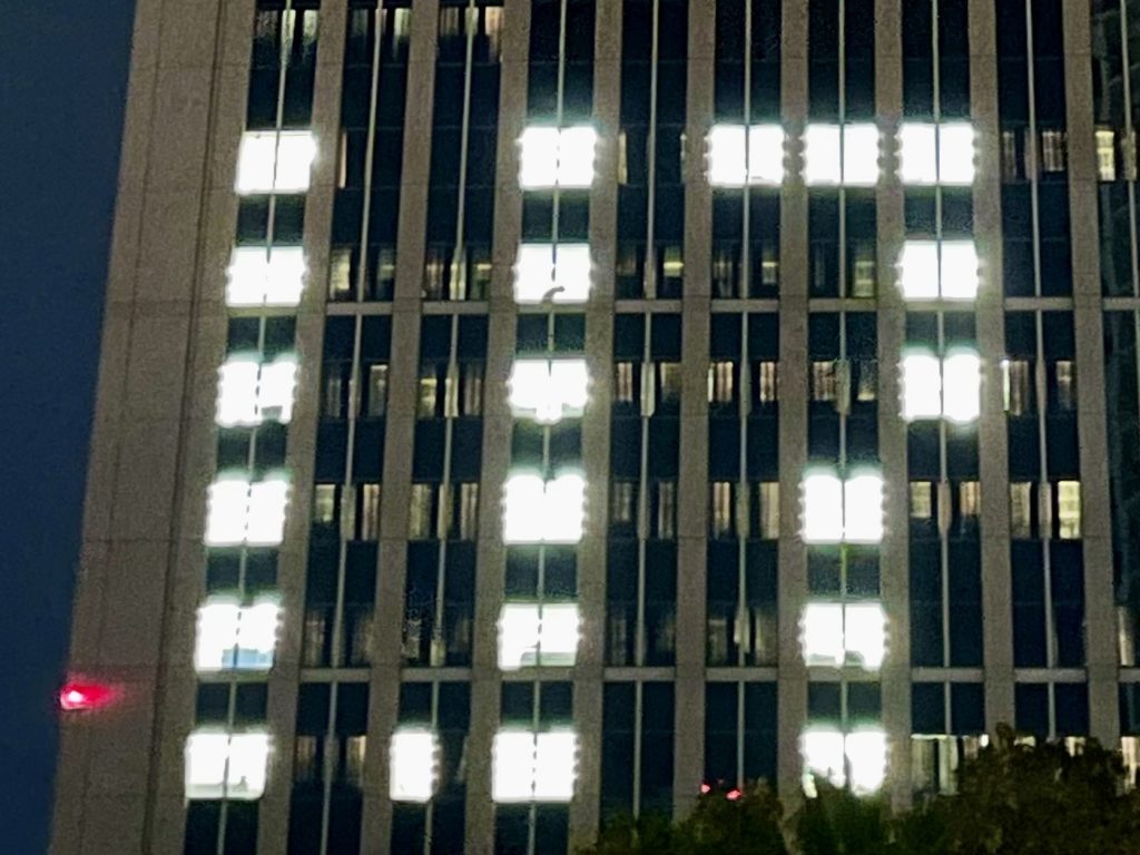 「神戸関電ビルディング」の窓に、「1.17」の文字が浮かび上がった（1月17日朝＝東遊園地）