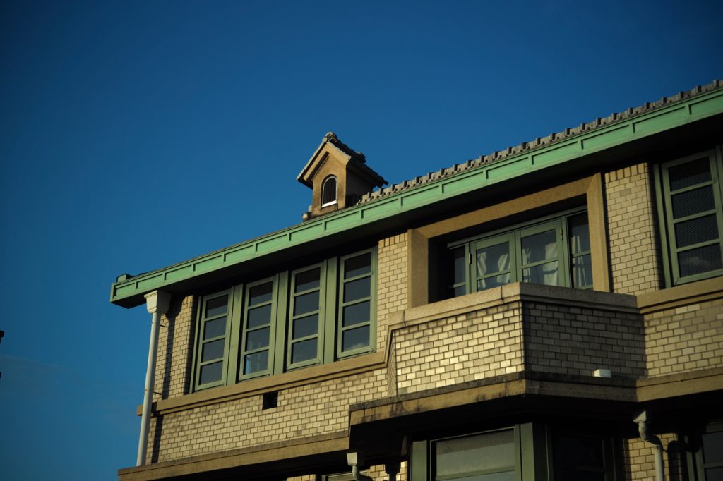 緑色の瓦屋根と外壁のタイルが特徴的な丸福樓の外観