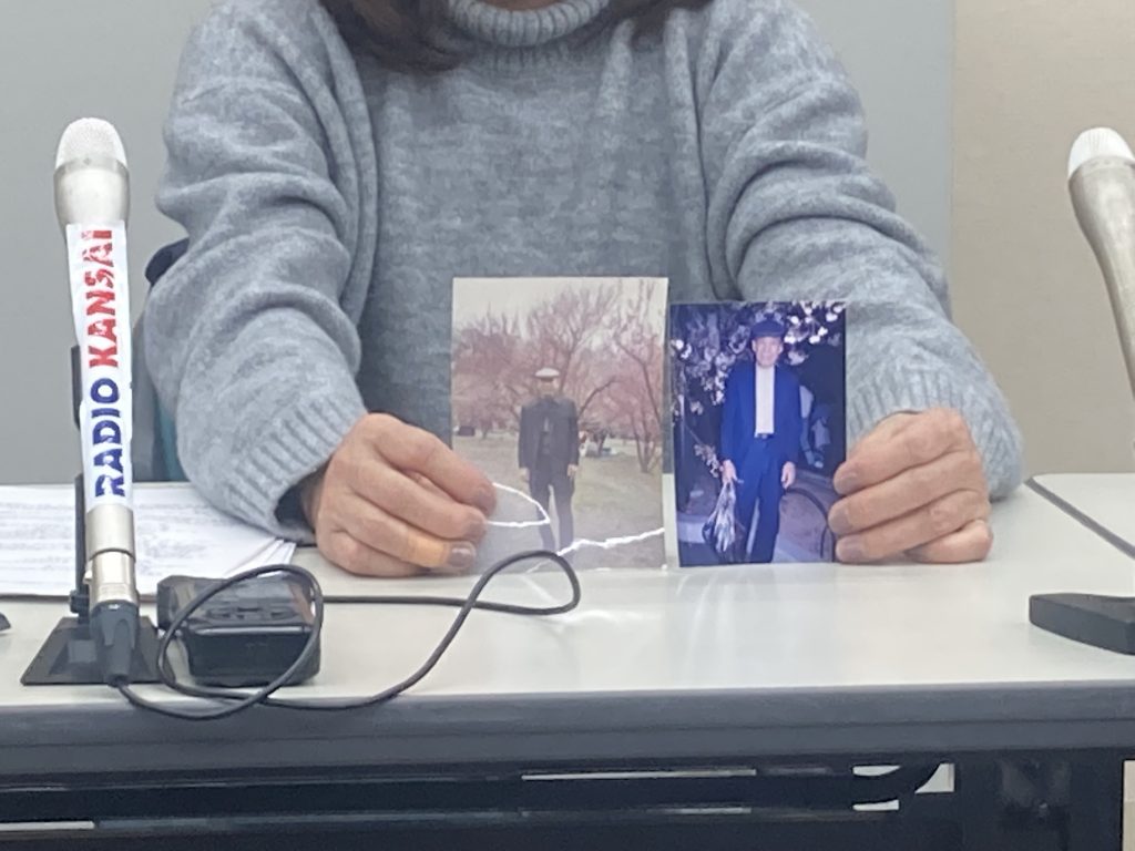 亡き父親の写真を手に会見する長女（2022年2月22日午後・神戸市内）