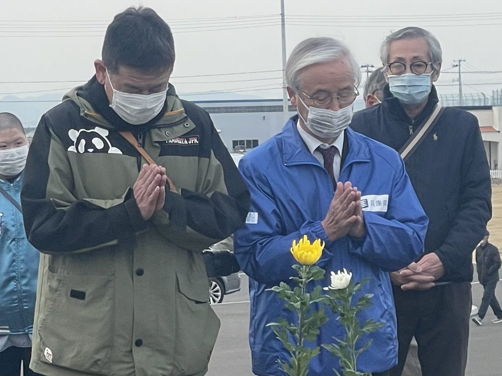 献花し手を合わせる（左から）閖上地区の町内会長・長沼俊幸さん、ひょうごボランタリープラザの高橋守雄所長（3月11日＝宮城県名取市）