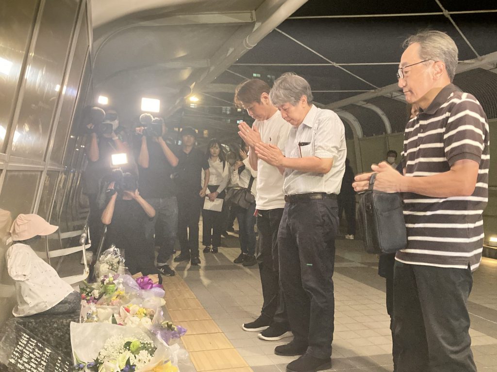 歩道橋上の慰霊碑「想の像」に献花、合掌する遺族ら〈2023年7月21日 午後8時45分 兵庫県明石市〉