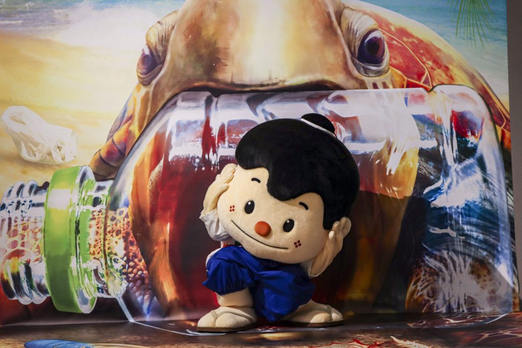 加東アート館の新しいトリックアートの前でポーズをとる、加東市のキャラクター「加東伝の助」（画像提供：加東市）