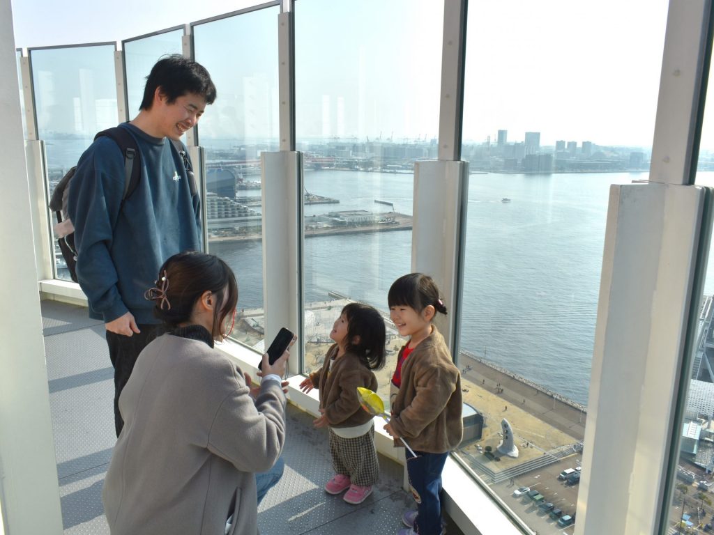 屋上展望デッキで写真を撮る井口さん一家