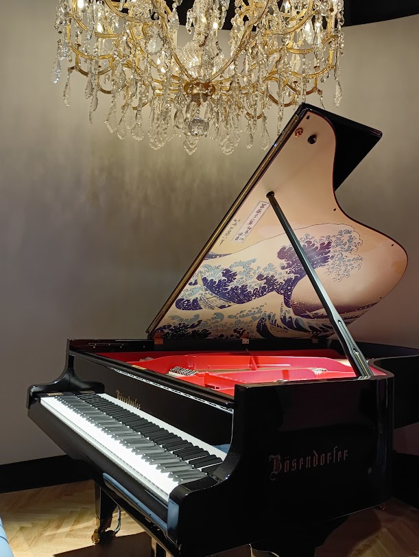 ベーゼンドルファーグランドピアノ「The Great Wave off Kanagawa(神奈川沖浪裏）」とシャンデリア　（オーストリア館内）