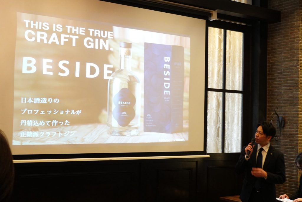 大阪市内で開かれたお披露目会で、クラフトジン『BESIDE』の特徴などを説明する、菊正宗酒造・マーケティング課の田上翼課長