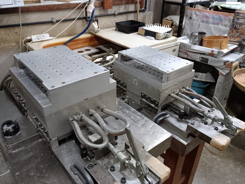 絵ろうそくなどをつくる機械　型に蝋を流し込むのは手作業だ