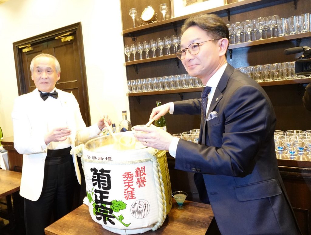 菊正宗の『純米樽酒』とクラフトジンを使ったオリジナルカクテルをグラスに注ぐ　バーテンダーの西田稔さん（左）と嘉納治郎右衞門社長（右）