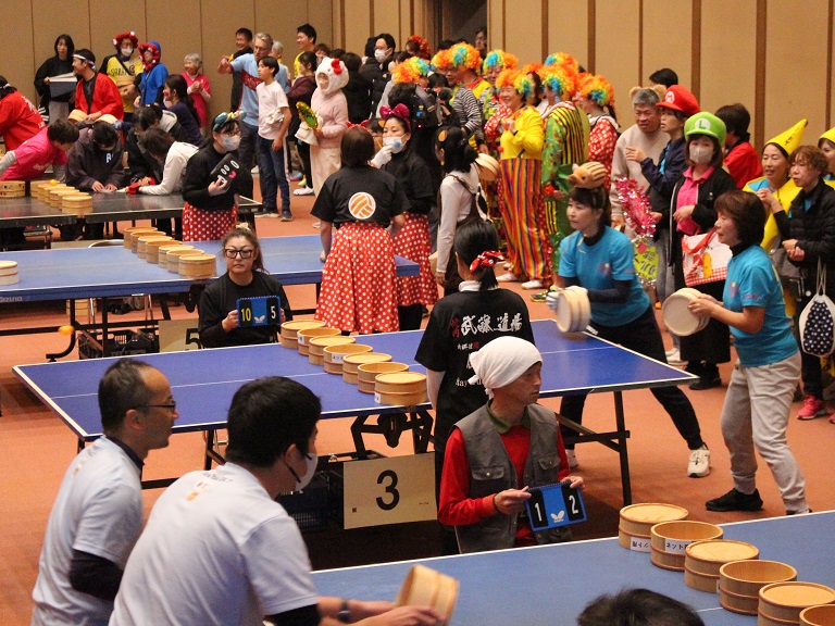 丹波篠山市発祥の『桶ット卓球』。ラケットとネットに風呂桶を使用し、サーブ時に「アー湯（ユー）桶（オーケー）？」「桶（オーケー）」と声を掛け合う（画像提供：丹波篠山市）
