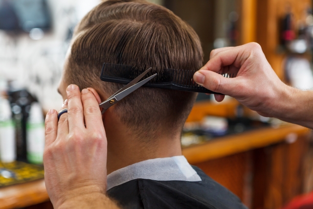 理髪店で髪を切られる男性のイメージ