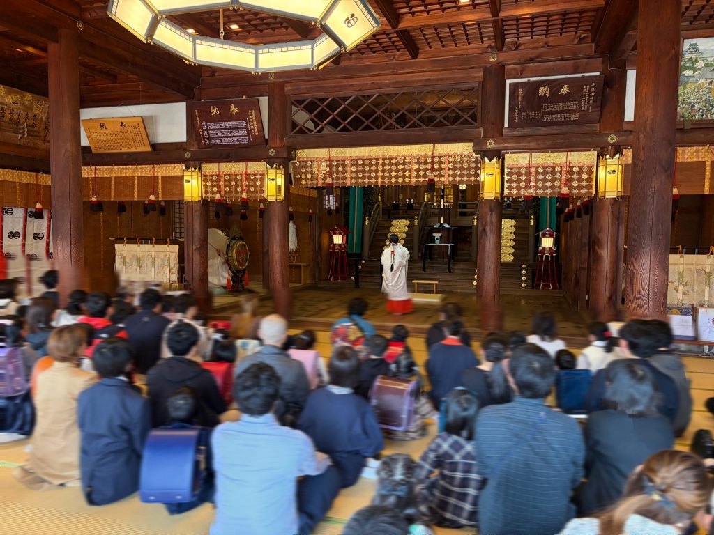 巫女の舞を見つめる子供たち