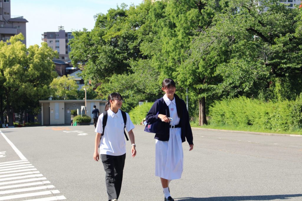 スラックスの制服で登校する生徒（左）とワンピースの制服で登校する生徒（右）